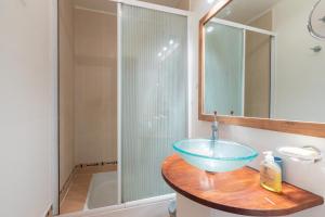 La salle de bains est pourvue d'un lavabo bleu et d'une douche. dans l'établissement La Nuit en Rose - 3 chambres - Balcon, à LʼHay-les-Roses