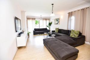 a living room with a couch and a table at Spacious Menlyn Maine Villa in Pretoria