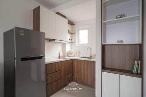 a kitchen with a refrigerator and wooden cabinets at Lux Westlake Studio in Hanoi