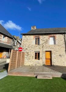 uma casa com um deque de madeira em frente em Petite Maison Cosy - Sérent Centre em Sérent