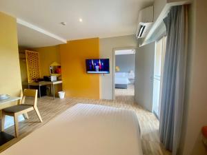 una stanza con un letto e una TV a parete di Beehive Boutique Hotel Phuket a Phuket