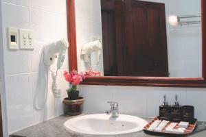 um lavatório de casa de banho com um espelho e um telefone em khampiane hotel em Ban Nongdouang