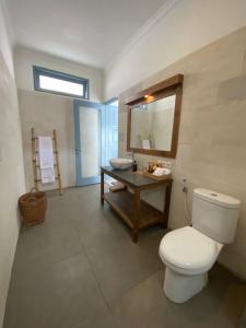 une salle de bain avec toilettes, lavabo et miroir dans l'établissement Kubuwatu Boutique Accommodation, à Gili Trawangan
