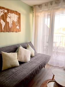un sofá con almohadas en la sala de estar en Le Rangueil entrée autonome Parking privé, en Toulouse