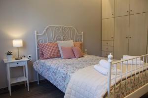 a bedroom with a white bed with pillows on it at Casa Di Calma Four Seasons Guest House in Kastríon