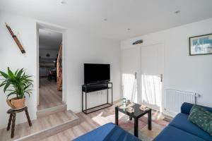 a living room with a blue couch and a tv at Jolie maison pour 6 personnes au Guilvinec in Le Guilvinec