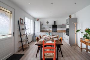 Jolie maison pour 6 personnes au Guilvinec في لو جويلفينيك: مطبخ وغرفة طعام مع طاولة وكراسي