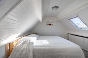 Jolie maison pour 6 personnes au Guilvinec في لو جويلفينيك: غرفة نوم بسرير أبيض في العلية