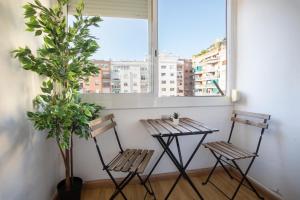 2 Stühle und ein Tisch vor einem Fenster in der Unterkunft 51flo1024 -Well located apartment in Sant Antoni in Barcelona