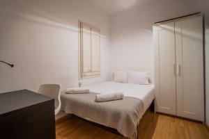 ein kleines weißes Schlafzimmer mit einem Bett und einem Fenster in der Unterkunft 51flo1024 -Well located apartment in Sant Antoni in Barcelona