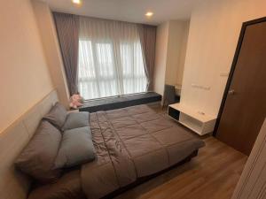 een groot bed in een kamer met een groot raam bij The prio apartment chiangmai airport in Chiang Mai