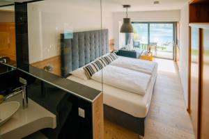 a bedroom with a bed and a sink and a mirror at Seehotel Hoffmann in Steindorf am Ossiacher See