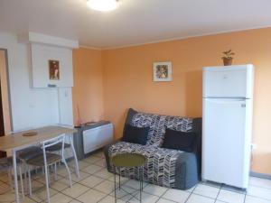 cocina y sala de estar con sofá y mesa en Gîte à la "traverse" des chemins en Lalbenque