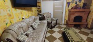 - un salon avec un canapé et une cheminée dans l'établissement Гостевая комната, à Tchernivtsi