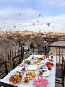 einen Tisch mit Speiseplatten und Heißluftballons in der Unterkunft Cappadocia sightseeing Hotel in Goreme