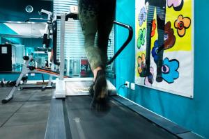 a person stepping on a treadmill in a gym at Hotel 87 eighty-seven - Maison d'Art Collection in Rome