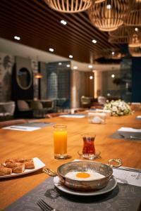 una mesa con un plato de huevos y un vaso de zumo de naranja en Richmond Istanbul, en Estambul