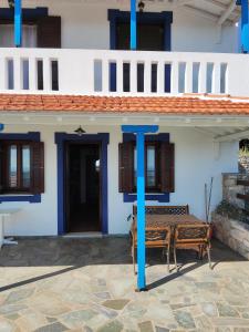 une maison avec un pôle bleu devant elle dans l'établissement Villa George, à vieille ville d'Alonissos