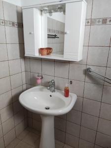 La salle de bains est pourvue d'un lavabo blanc et d'un miroir. dans l'établissement Villa George, à vieille ville d'Alonissos