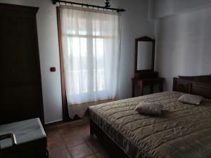 - une chambre avec un lit, une fenêtre et un miroir dans l'établissement Villa George, à vieille ville d'Alonissos
