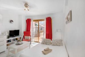 Los Geranios 304 في أديخي: غرفة معيشة مع أريكة بيضاء وستائر حمراء