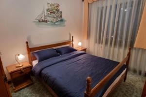 a bedroom with a bed with blue sheets and a window at APARTMENT GORDANA A4+2 FOR 6 PAX NATURE PARK in Lokve