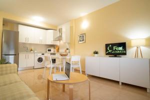 cocina y sala de estar con mesa y ordenador portátil en Miramar 3 en San Sebastián de la Gomera