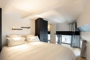 a bedroom with a large white bed with white pillows at LE M Luxueux appartement sur le Vieux port de Marseille in Marseille