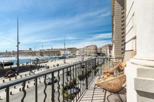 a balcony with a view of a beach and buildings at LE M Luxueux appartement sur le Vieux port de Marseille in Marseille