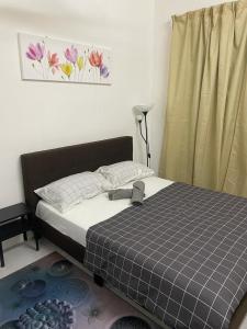 ein Schlafzimmer mit einem Bett und einem Fenster mit Blumen an der Wand in der Unterkunft D Naurah Meritus Guesthouse in Perai