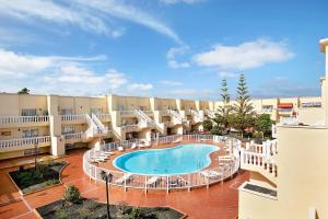 a large courtyard with a swimming pool in front of a building at Sol y Mar Caleta de Fuste in Caleta De Fuste