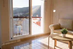 a living room with a chair and a table and a window at Miramar 4 in San Sebastián de la Gomera