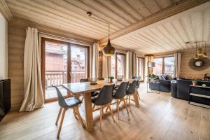 una sala da pranzo con tavolo e sedie in legno di Apartment Cervino Monriond Courchevel - by EMERALD STAY a Courchevel