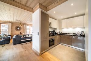 una cocina abierta y una sala de estar en una casa en Apartment Cervino Monriond Courchevel - by EMERALD STAY, en Courchevel