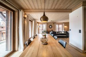 a large wooden table in a room with chairs at Apartment Cervino Monriond Courchevel - by EMERALD STAY in Courchevel