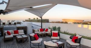 een patio met stoelen en tafels en een parasol bij ANEW Hotel Green Point Cape Town in Kaapstad