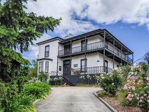 an exterior view of a white house with a balcony at The Dragonfly Inn in Launceston