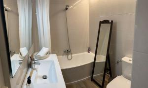 a bathroom with a tub and a sink and a toilet at Renttarter Sans Espais in El Tarter +30 photos