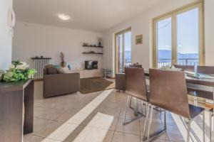 un soggiorno con un divano, un tavolo e delle sedie di Casa Andrea Varenna a Perledo