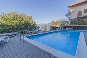 una piscina con sedie accanto a un edificio di Casa Andrea Varenna a Perledo