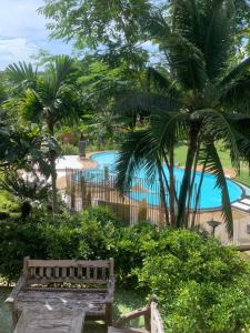 a wooden bench in front of a swimming pool at Suanya Kohkood Resort and Spa in Ko Kood