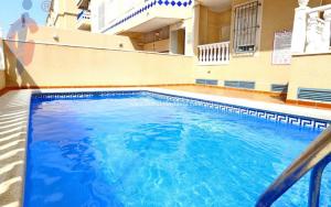 una piscina de agua azul en un edificio en Apartamento Dama de Guardamar, en Guardamar del Segura