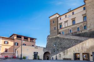 ein Gebäude neben einer Mauer neben einem Gebäude in der Unterkunft Il Confessionale in Castelnuovo di Porto