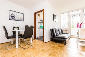Work & Stay Apartment Monheim في مونهيم: غرفة معيشة مع طاولة وكراسي