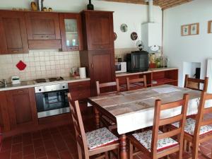 una cocina con armarios de madera, mesa y sillas en Martonvendeghaz 2 en Gelse