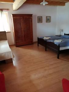 1 dormitorio con 1 cama y suelo de madera en Martonvendeghaz 1, en Erdeimajor