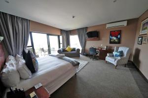 a hotel room with a large bed and a desk at Over The Moon Guesthouse in Johannesburg