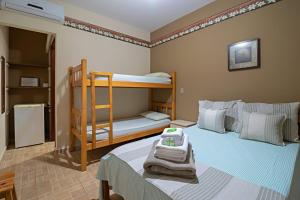 1 dormitorio con 2 literas y toallas en la cama en Pousada Rota das Cachoeiras, en Patrimônio São Sebastião