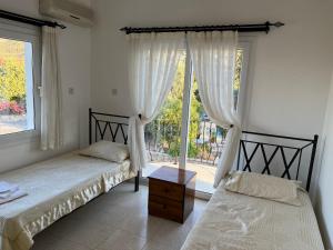 a bedroom with two beds and a large window at Villa Zeytin - Private Pool Villa in Vasilia +128 photos