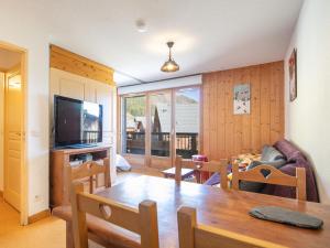 ein Wohnzimmer mit einem Esstisch und einem TV in der Unterkunft Les Marmottes- 35 Appart Lumineux- 5 pers in Saint-Sorlin-dʼArves